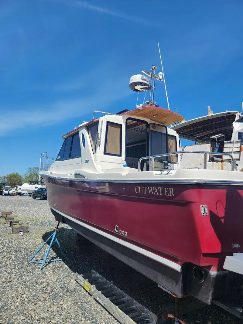 Slide: The Image of 2011 Cutwater 28 boat with red hull on dry dock. - 2