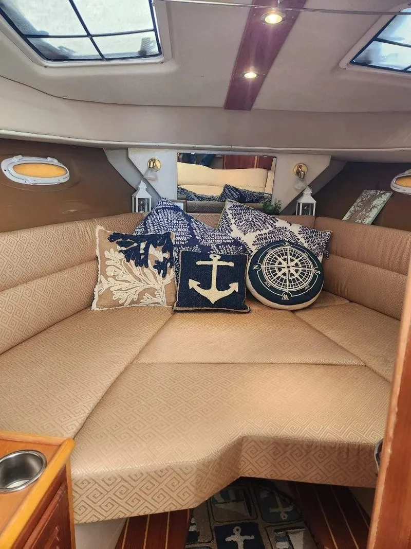 Slide: The Image of Interior of 2011 Cutwater 28 boat with nautical-themed cushions and cozy seating. - 5