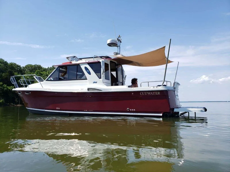 Slide: The Image of 2011 Cutwater 28 boat anchored on calm water with a canopy. - 7