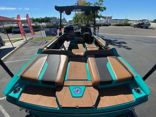Slide: The Image of 2022 Axis Wake Research T250 boat with teal and brown seating in a parking lot. - 10