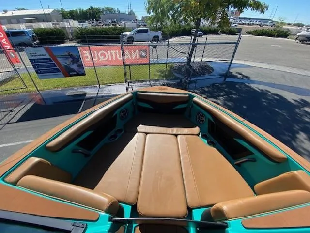 Slide: The Image of 2022 Axis Wake Research T250 boat with brown and teal seating, parked outdoors. - 12