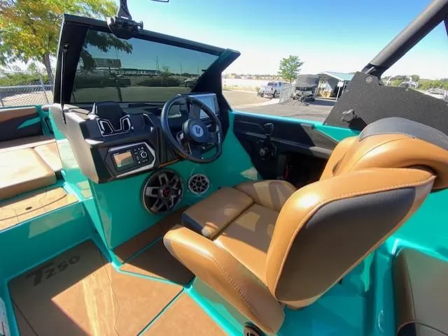 Slide: The Image of 2022 Axis Wake Research T250 boat interior with brown seats and modern dashboard. - 19