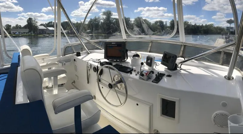 Slide: The Image of 2007 Duffy Aft Cabin boat helm with steering wheel and navigation equipment on a sunny day. - 14