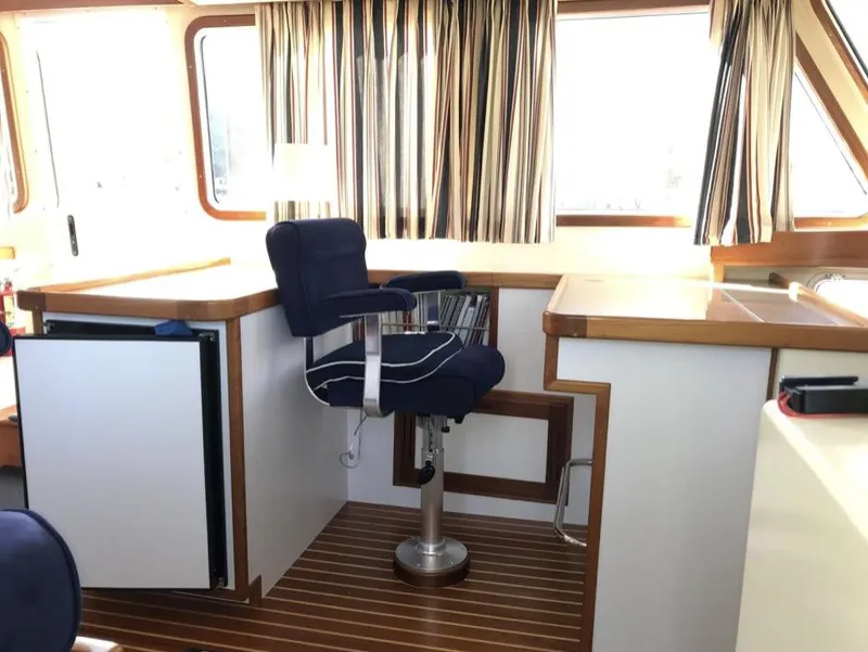 Slide: The Image of 2007 Duffy Aft Cabin interior with captain's chair, striped curtains, and wood accents. - 16