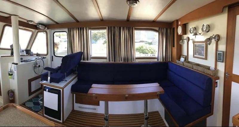 Slide: The Image of 2007 Duffy Aft Cabin interior with blue seating, wooden table, and helm station. - 17