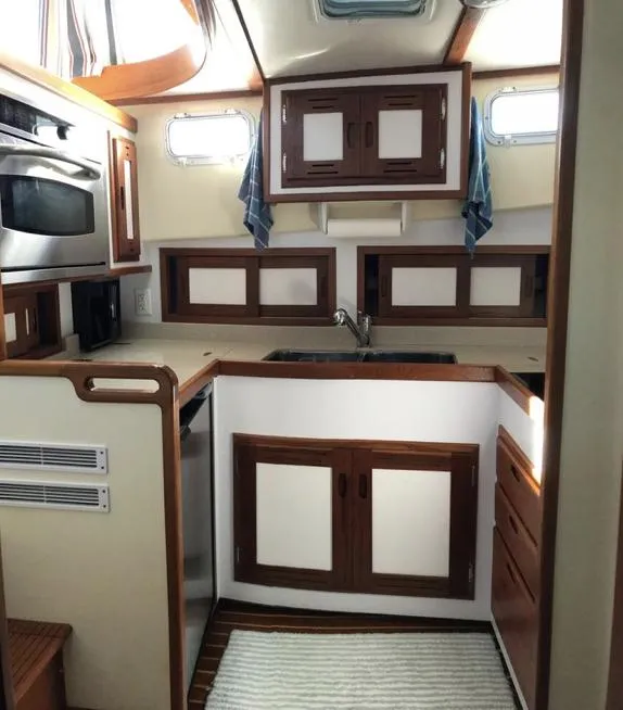 Slide: The Image of 2007 Duffy Aft Cabin kitchen with wood cabinets, stainless steel appliances, and natural light. - 23