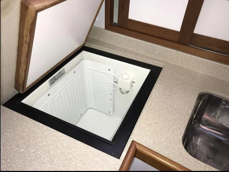 Slide: The Image of Open storage compartment in 2007 Duffy Aft Cabin boat kitchen area. - 24