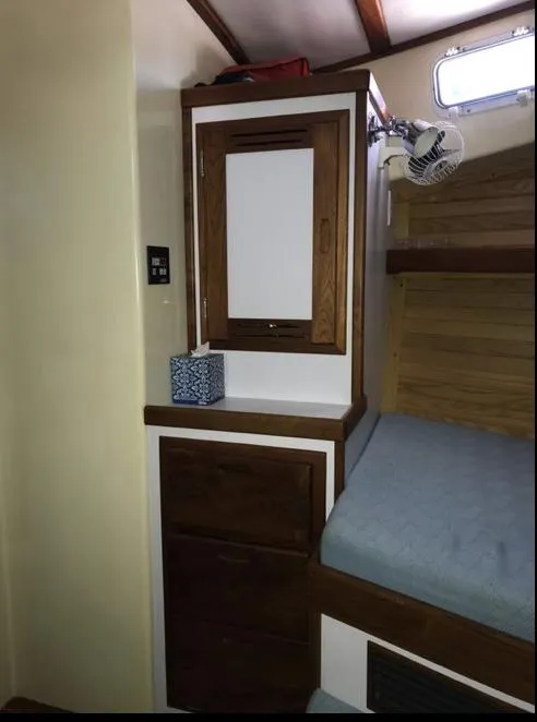 Slide: The Image of 2007 Duffy Aft Cabin interior with wooden cabinetry and bed. - 28