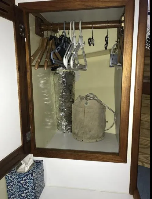 Slide: The Image of Wooden closet in a 2007 Duffy Aft Cabin with hangers and storage items. - 36