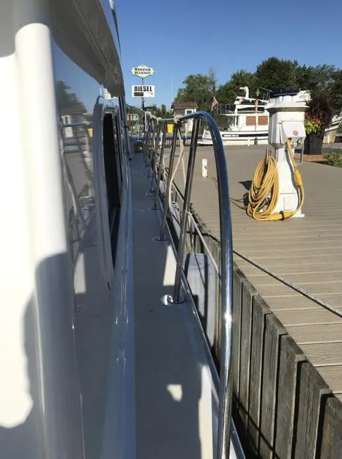 Slide: The Image of 2007 Duffy Aft Cabin boat docked, showing side view with railing and marina background. - 7