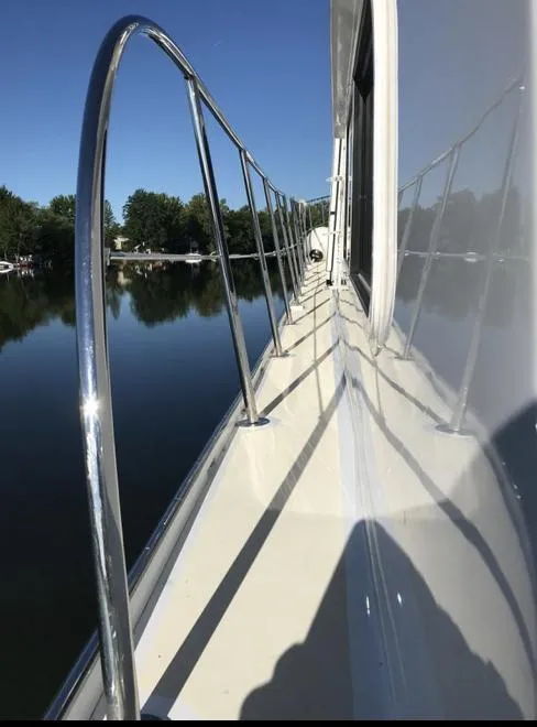 Slide: The Image of 2007 Duffy Aft Cabin boat deck with railing, reflecting on calm water. - 8