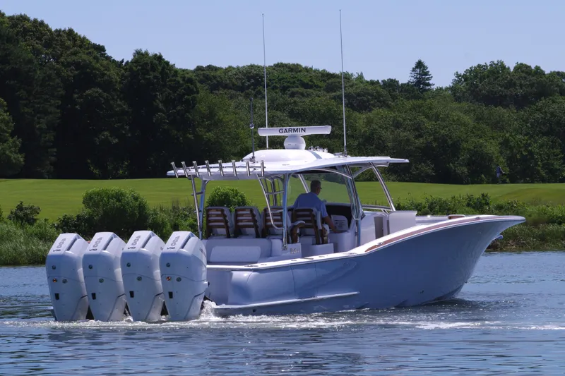 Slide: The Image of 2025 Mag Bay 43 CC boat with four outboard engines cruising on a lake. - 10