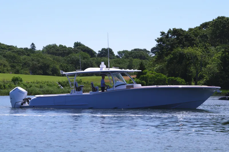 Slide: The Image of 2025 Mag Bay 43 CC boat cruising on a serene lake. - 12