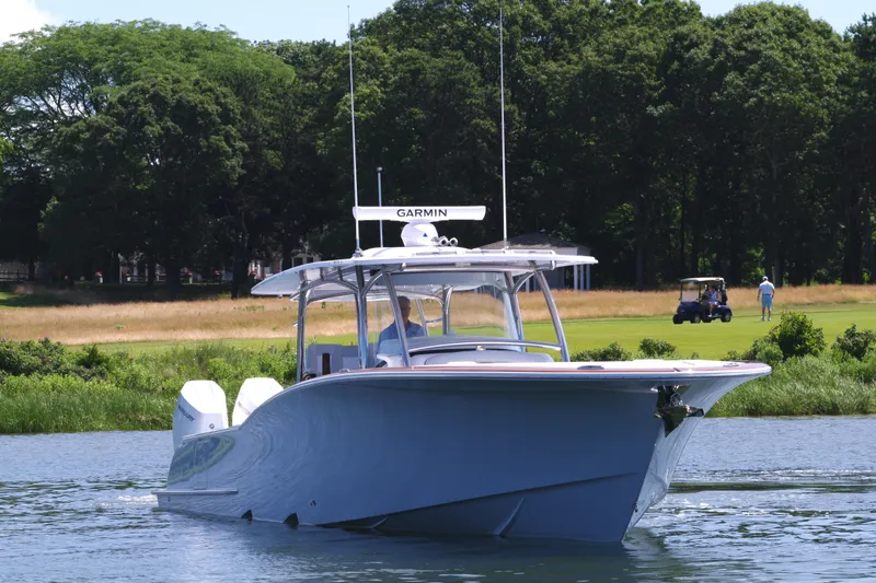 Slide: The Image of 2025 Mag Bay 43 CC boat on water with lush green background. - 14