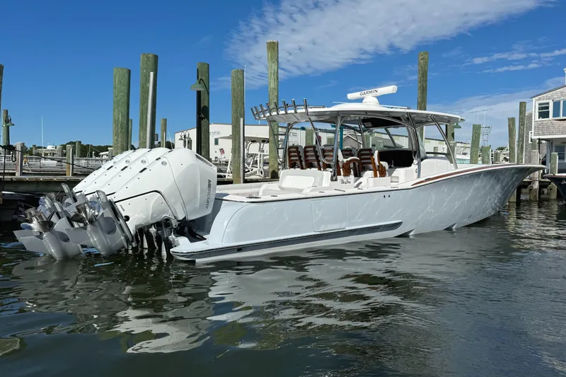 Slide: The Image of 2025 Mag Bay 43 CC boat docked at marina with triple outboard engines. - 20