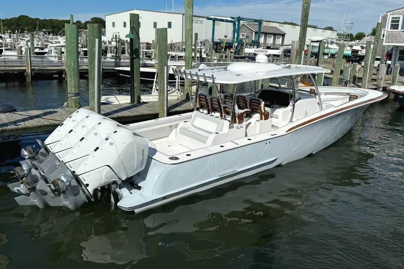 Slide: The Image of 2025 Mag Bay 43 CC boat docked at a marina with multiple outboard engines. - 21
