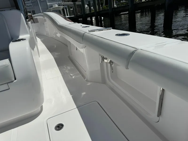 Slide: The Image of 2025 Mag Bay 43 CC boat deck with white seating and storage compartments. - 33