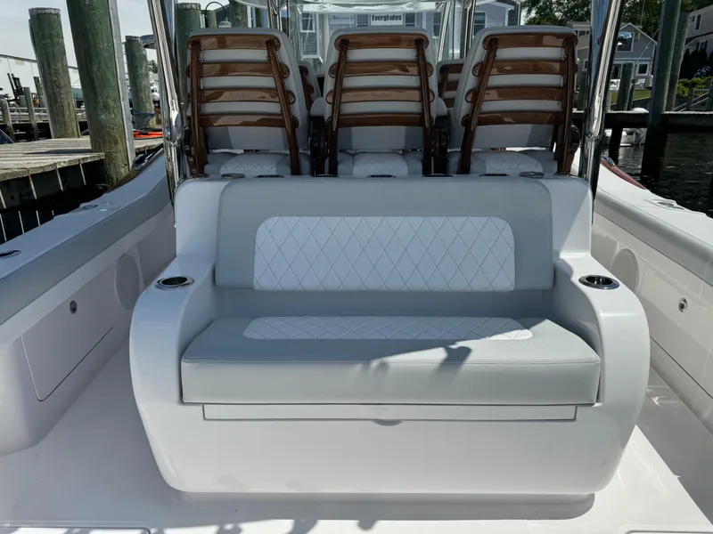 Slide: The Image of 2025 Mag Bay 43 CC boat interior with cushioned seating and wooden chairs. - 34