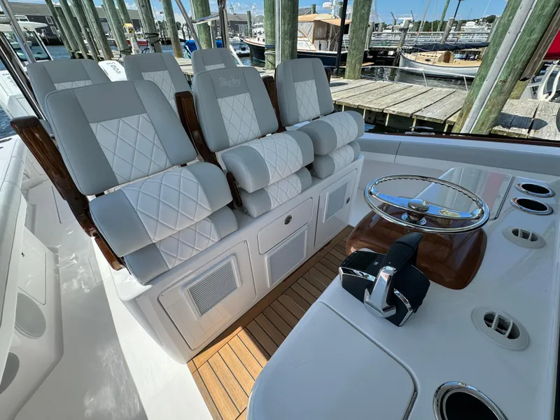 Slide: The Image of Luxurious seating on the 2025 Mag Bay 43 CC boat, docked at a marina. - 44