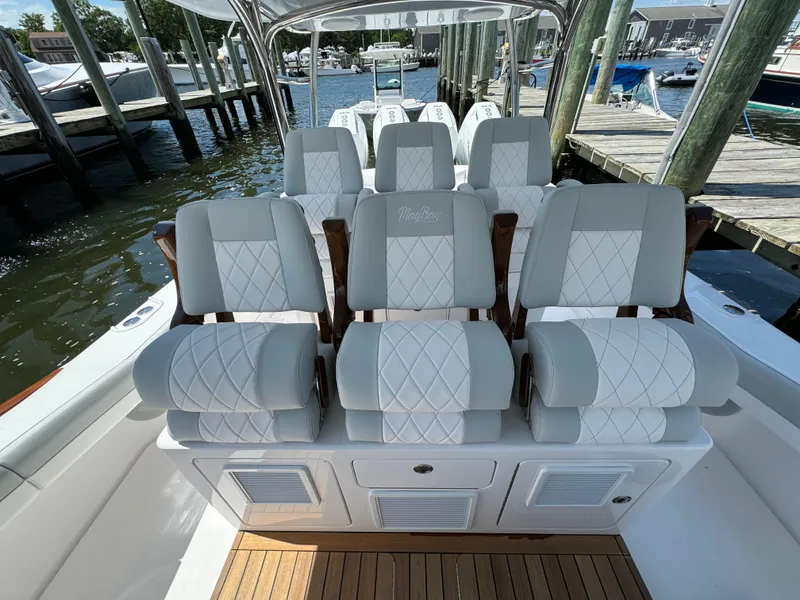 Slide: The Image of Luxurious seating on the 2025 Mag Bay 43 CC boat at a marina. - 46