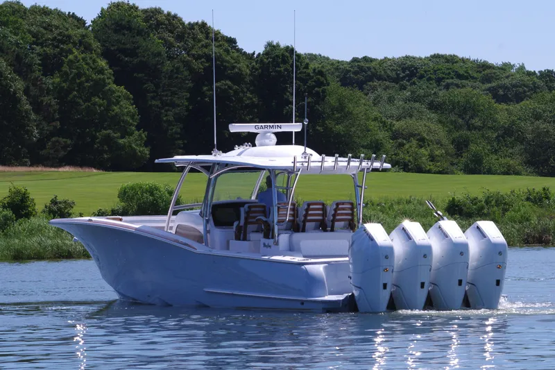 Slide: The Image of 2025 Mag Bay 43 CC boat with four outboard engines on a calm lake. - 5