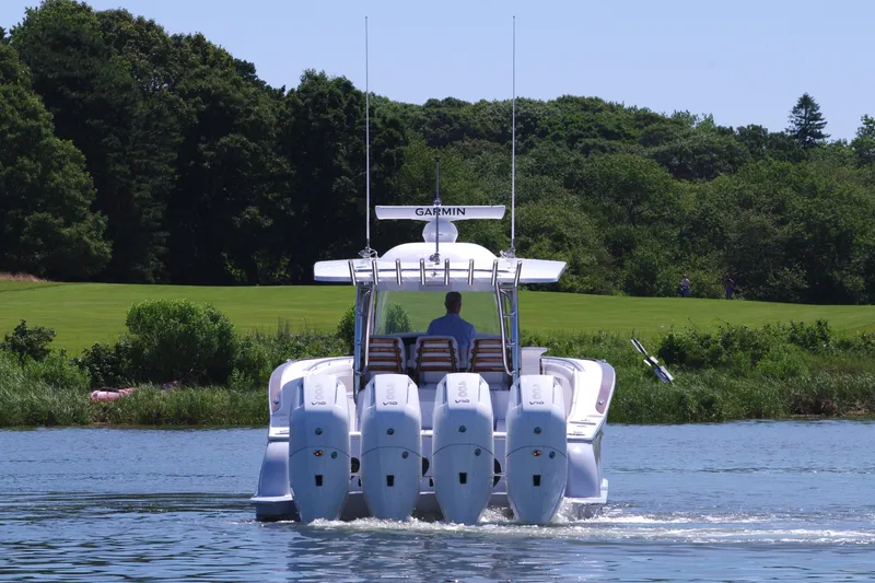 Slide: The Image of 2025 Mag Bay 43 CC boat with four outboard engines on a calm lake. - 7