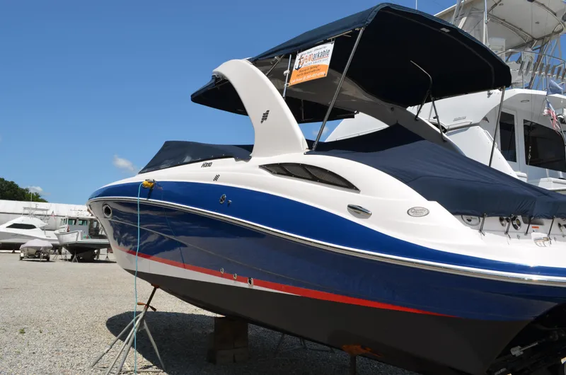 Slide: The Image of 2013 Four Winns H310 boat with blue and white hull, docked on land. - 10