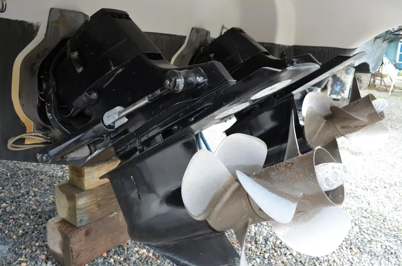 Slide: The Image of Close-up of 2013 Four Winns H310 boat propellers and outdrives on wooden blocks. - 12