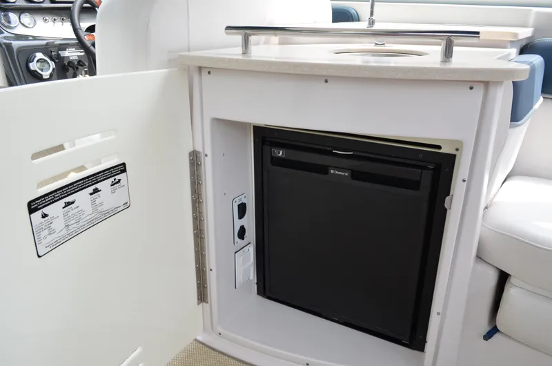 Slide: The Image of 2013 Four Winns H310 boat interior with built-in Dometic refrigerator. - 25