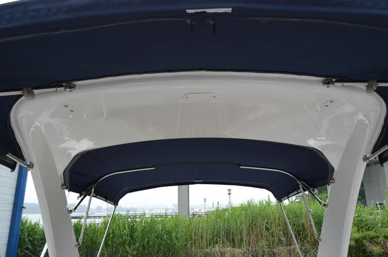 Slide: The Image of 2013 Four Winns H310 boat with blue canopy and white frame. - 28