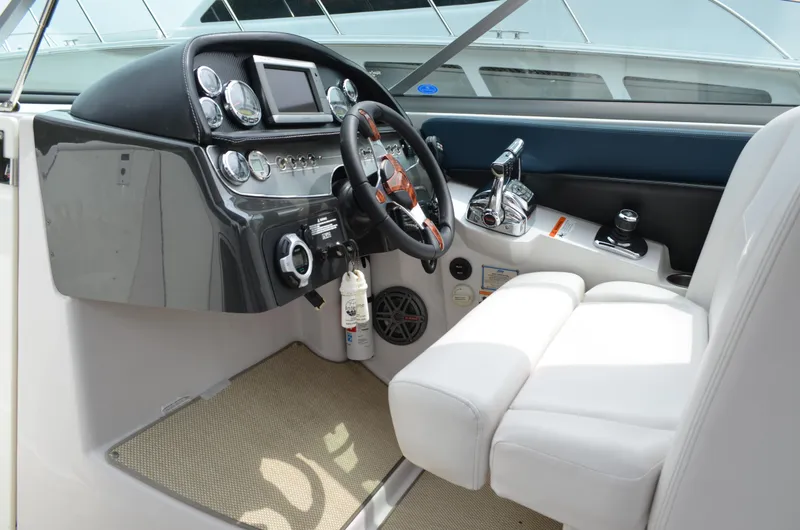 Slide: The Image of 2013 Four Winns H310 boat cockpit with steering wheel and control panel. - 31