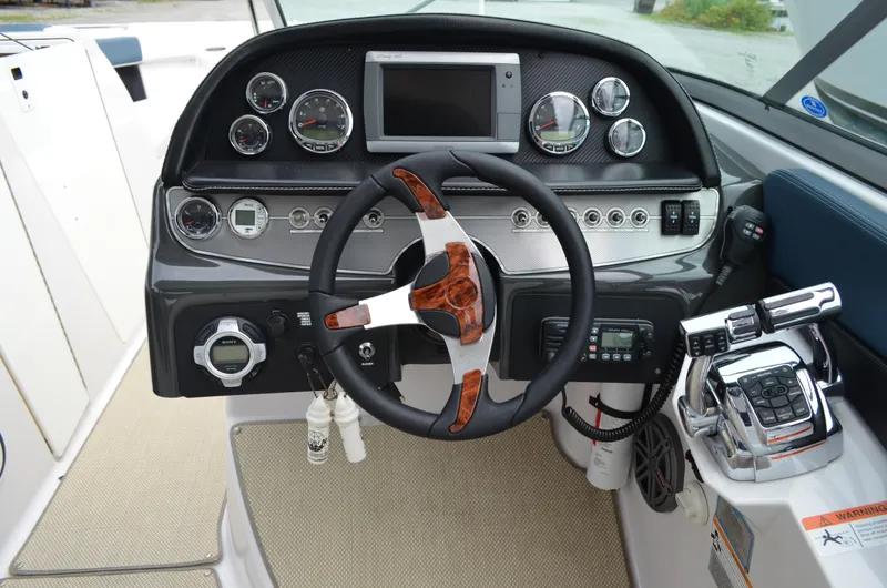 Slide: The Image of 2013 Four Winns H310 boat dashboard with steering wheel and control panel. - 33