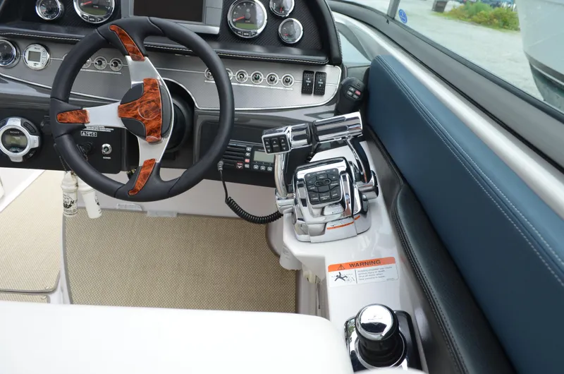 Slide: The Image of 2013 Four Winns H310 boat helm with steering wheel and control panel. - 34