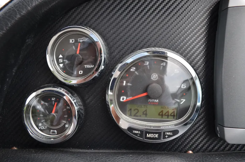 Slide: The Image of 2013 Four Winns H310 boat dashboard gauges showing RPM, trim, and voltage. - 37