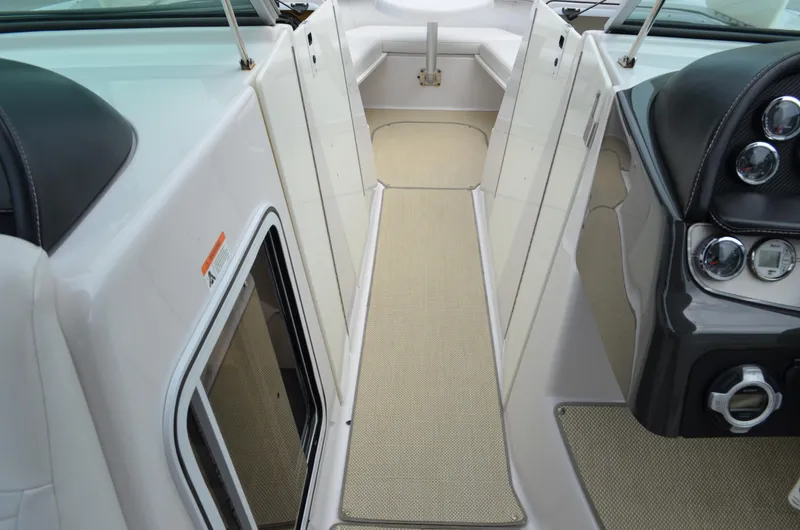 Slide: The Image of 2013 Four Winns H310 boat interior, featuring beige carpet and sleek dashboard controls. - 38