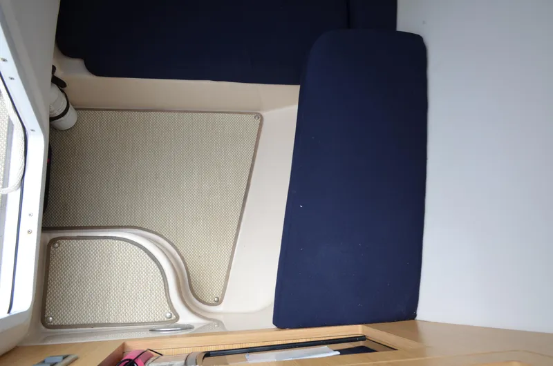 Slide: The Image of Interior cabin of 2013 Four Winns H310 boat with blue cushions and beige flooring. - 43