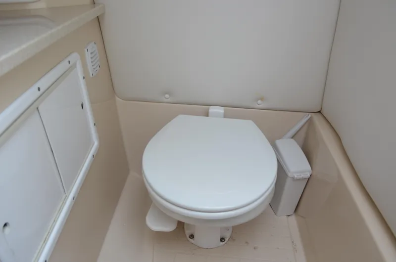 Slide: The Image of 2013 Four Winns H310 boat bathroom with toilet and storage compartments. - 48