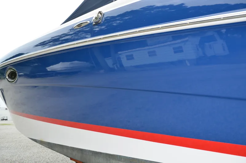 Slide: The Image of Close-up of 2013 Four Winns H310 boat hull in blue with red and white stripes. - 6