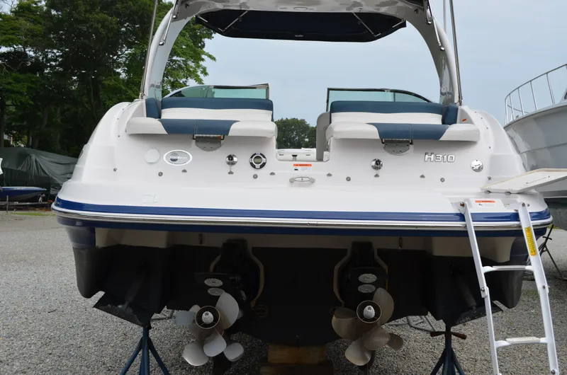 Slide: The Image of 2013 Four Winns H310 boat rear view with dual propellers and swim platform. - 8