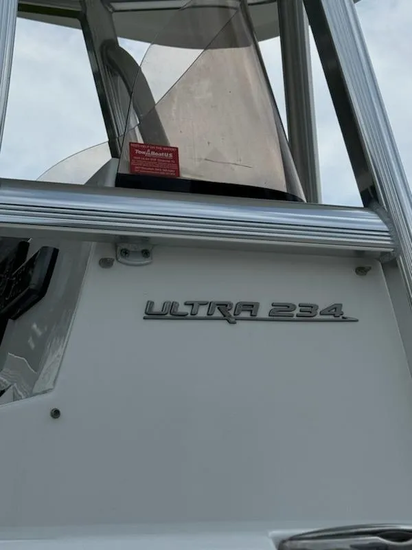 Slide: The Image of 2016 Sea Hunt Ultra 234 boat model nameplate on white exterior. - 4