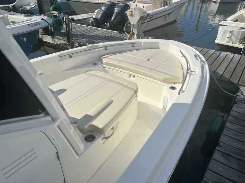Slide: The Image of 2024 Boston Whaler 220 Dauntless boat docked, featuring spacious seating and clean design. - 3