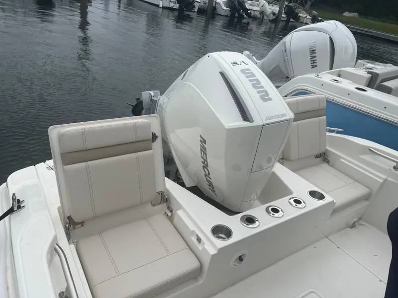 Slide: The Image of 2025 Boston Whaler 220 Dauntless boat with Mercury engine, docked at marina. - 4