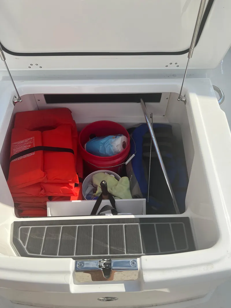 Slide: The Image of Storage compartment of 2024 Boston Whaler 220 Dauntless with life jackets and boating gear. - 7