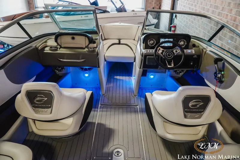 Slide: The Image of 2022 Crownline 220 SS SURF boat interior with blue LED lighting and modern dashboard. - 9