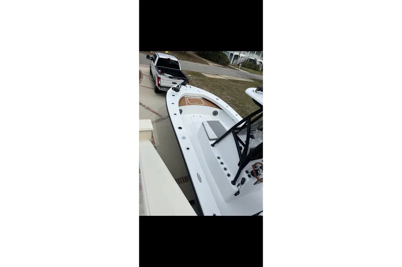 Slide: The Image of White 2021 ZCB 26 Freemason boat on trailer, parked beside a white truck. - 10