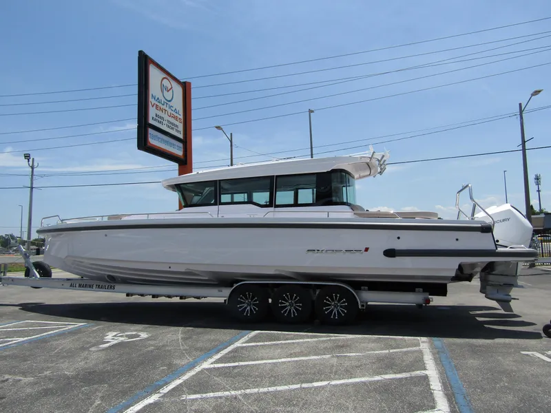 Slide: The Image of 2024 Axopar 37XC CROSS CABIN boat on trailer in parking lot. - 0