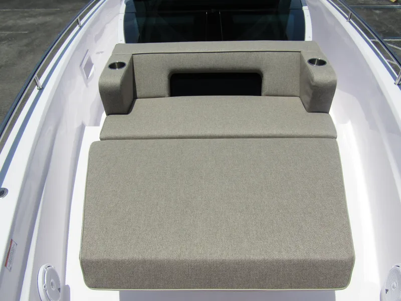Slide: The Image of 2024 Axopar 37XC CROSS CABIN sunbed with gray cushions and cup holders. - 10
