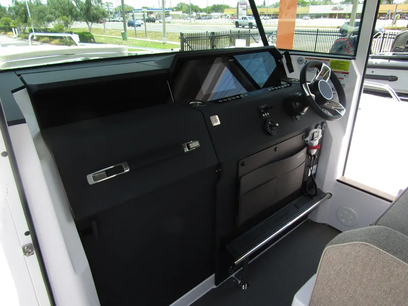 Slide: The Image of 2024 Axopar 37XC CROSS CABIN helm station with modern controls and steering wheel. - 12