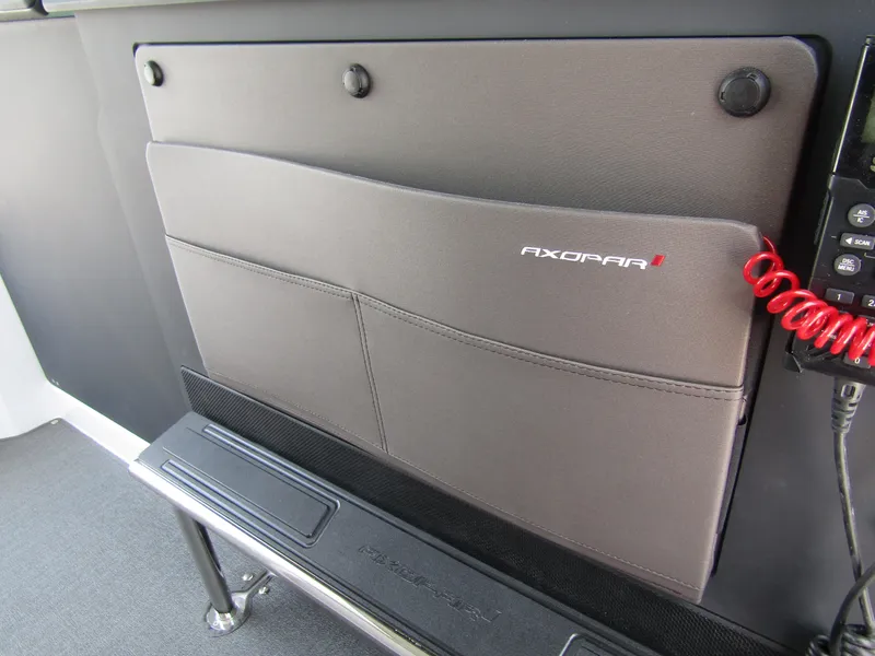 Slide: The Image of Axopar 37XC CROSS CABIN 2024 interior storage compartment with branded cover. - 18