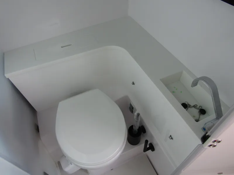 Slide: The Image of 2024 Axopar 37XC CROSS CABIN bathroom with modern toilet and compact sink. - 24